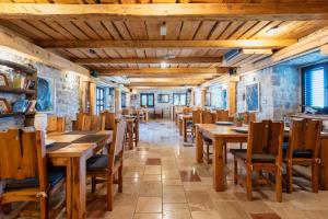a dining room with wooden tables and chairs at Forte Rose Hotel in Herceg-Novi