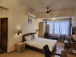 a hotel room with a bed and a window at Vagator Beachside Apartment with Pool by Welkin Stays in Vagator +26 photos