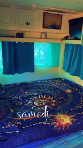 a bedroom with a bed with a samedi sign on it at Roulotte individuelle dans le maquis Corse in Pianottoli-Caldarello