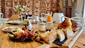 a wooden table with bread and other foods on it at La Villa Tonga - Chambres d'hôtes à Fronsac in Fronsac