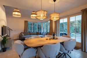 a living room with a wooden table and chairs at Lodge met eigen wellness onder de bomen in Lochem