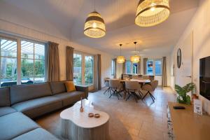 a living room with a couch and a table at Lodge met eigen wellness onder de bomen in Lochem