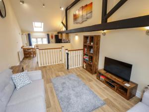 a living room with a couch and a flat screen tv at 3 The Old Drill Hall in Alford
