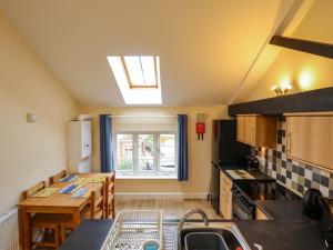 a small kitchen with a table and a window at 3 The Old Drill Hall in Alford