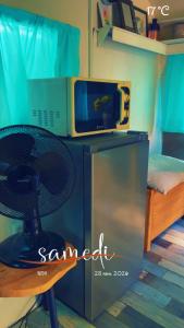 a room with a microwave and a table with a chair at Roulotte individuelle dans le maquis Corse in Pianottoli-Caldarello