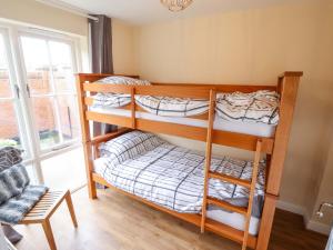 two bunk beds in a room with a window at 3 The Old Drill Hall in Alford