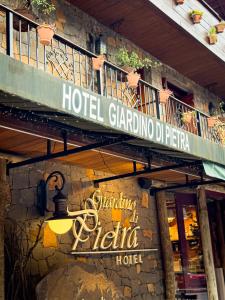 a hotel sign on the side of a building at Hotel Giardino Di Pietra in Gramado
