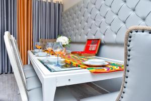 a white dining table and chairs with a tablecloth on it at THE AFRICAN PALACE- Free Airport Pick up - High Speed Starlink WiFi - Car Rental in Tamale