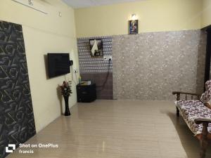 a room with a bathroom with a tv on a wall at Johan home stay AC in Thiruchendur +8 photos