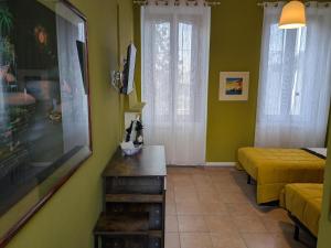 a room with two beds and a living room with green walls at Corte Meneghina-short stays in Buscate +16 photos