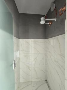 a bathroom with a shower with white marble tiles at Ideal Center in Nova Serrana