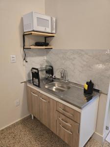 a kitchen with a sink and a microwave at Ideal Center in Nova Serrana +19 photos
