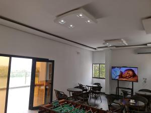 a room with tables and chairs and a flat screen tv at ADM HOTEL Grand-Lahou in Grand-Lahou