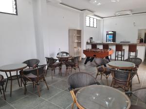 a room with tables and chairs and a table with a game at ADM HOTEL Grand-Lahou in Grand-Lahou