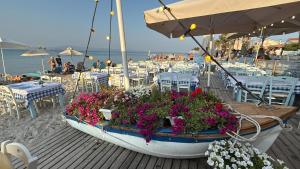 a boat with flowers in it on a beach at NIVAS Apartment Pefkochori in Pefkochori