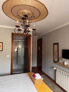a room with a bed and a chandelier at Hostal Casa San Nicolas in Molinaseca +85 photos