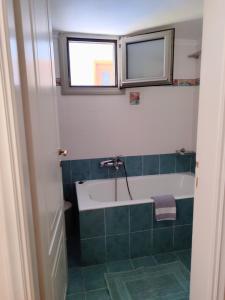 a bathroom with a bath tub and a window at Myrstia Apartments in Pyrgi Thermis +10 photos