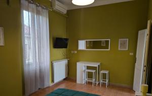 a green room with a table and a window at Corte Meneghina-short stays in Buscate