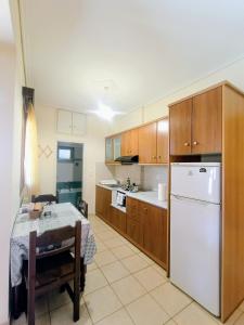 a kitchen with a table and a white refrigerator at Myrstia Apartments in Pyrgi Thermis