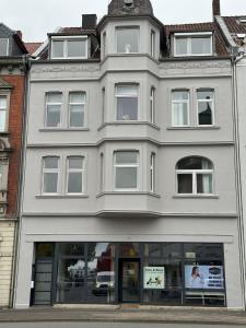 a white building with a clock on top of it at Historische Altbauwohnung im Zentrum von Detmold, Pauline in Detmold +7 photos