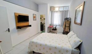 a bedroom with a bed and a tv on a wall at Studio Catete Flamengo in Rio de Janeiro