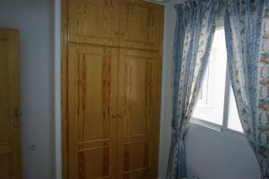 un armario de madera en una habitación con ventana en Apartamento La Mata, en La Mata