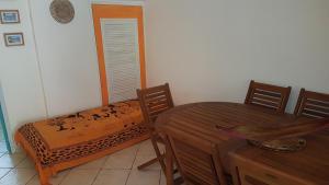 a dining room with a table and a bed at Location Marigot in Terre-de-Haut