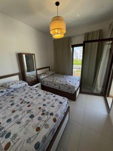 a bedroom with two beds and a chandelier at Marassi villa in El Alamein