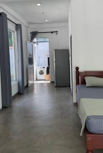a bedroom with a bed and a door to a kitchen at Hideaway in Bentota