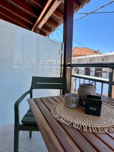 a wooden table and a chair on a balcony at Nido Estivo 2 in Nea Skioni
