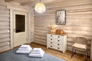 a room with a dresser and a chair with towels at Vila Mila in Mykulychyn