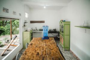 a kitchen with a wooden table with a blue vase on it at Comuna Tigabelas in Gisi