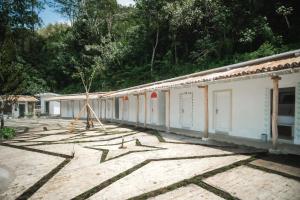 a group of white buildings with trees in the background at Comuna Tigabelas in Gisi