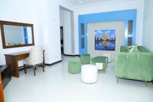 a living room with green chairs and a table at Palmyra resort in Jaffna