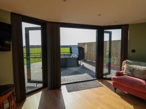 a living room with sliding glass doors and a couch at The Corn Silo in Ipswich