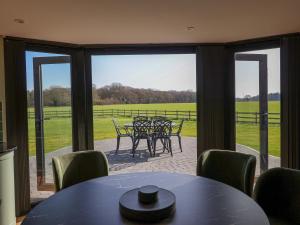 a dining room with a table and chairs and a patio at The Corn Silo in Ipswich