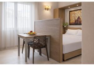 a bedroom with a bed and a table with a bowl of fruit at Le Residenze del Centro in Olbia