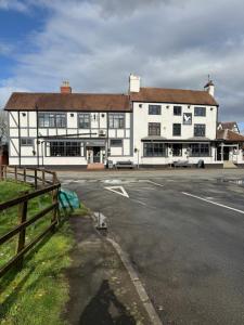 a large white building on the side of a street at Quality City Hotel Restaurant Free Parking in Upton Warren