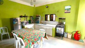 eine Küche mit einem Tisch und eine Küche mit grünen Wänden in der Unterkunft Real House in Real