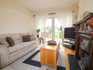 a living room with a couch and a tv at 5 Wallace Road in Loughborough
