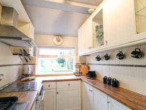 a kitchen with white cabinets and a window at 5 Wallace Road in Loughborough
