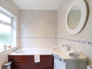 a bathroom with a tub and a sink and a mirror at 5 Wallace Road in Loughborough +16 photos