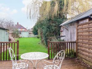 a patio with a table and chairs and a fence at 5 Wallace Road in Loughborough