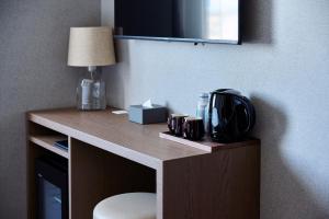 a desk in a hotel room with a table with a lamp at The Knot Utsunomiya in Utsunomiya