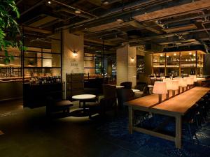 a restaurant with a table and chairs and a bar at The Knot Utsunomiya in Utsunomiya +4 photos