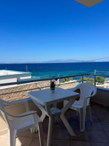 a table and chairs on a balcony with the ocean at Geomelos Theodoros Apartments in Chios