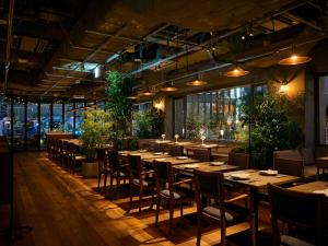 a restaurant with tables and chairs and plants at The Knot Utsunomiya in Utsunomiya