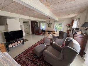 a living room with couches and a flat screen tv at Kuliniai by Stirniai lake Moletai district in Kuliniai