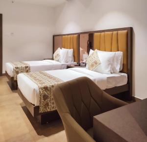 a hotel room with two beds and a couch at Hotel Camel managed by CLAY in Mundra +27 photos