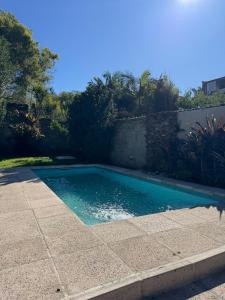 a swimming pool in a yard next to a wall at Alojamiento Zona Parque in Paraná